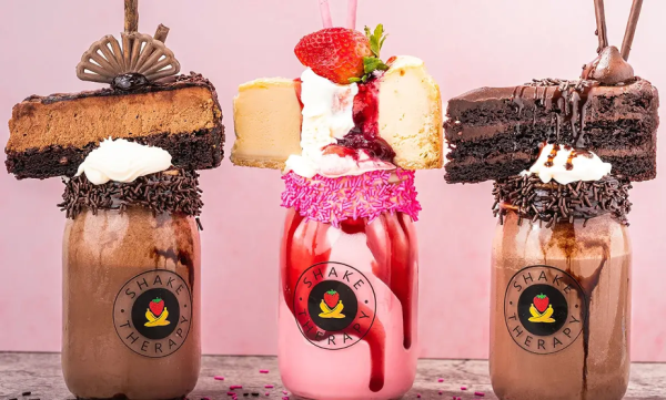 Three different milk shakes two chocolates and in the middle is strawberry